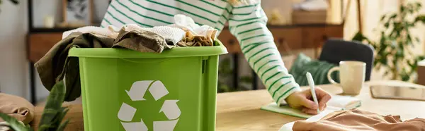 Uma jovem organiza roupas para reciclagem em um espaço acolhedor e ecológico, banner — Fotografia de Stock