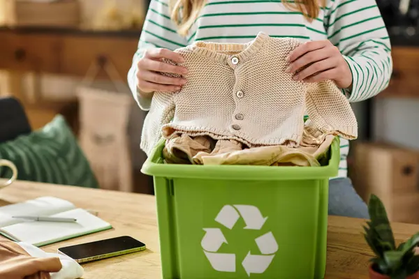 Uma jovem ordena e recicla suas roupas enquanto promove a sustentabilidade em casa. — Fotografia de Stock