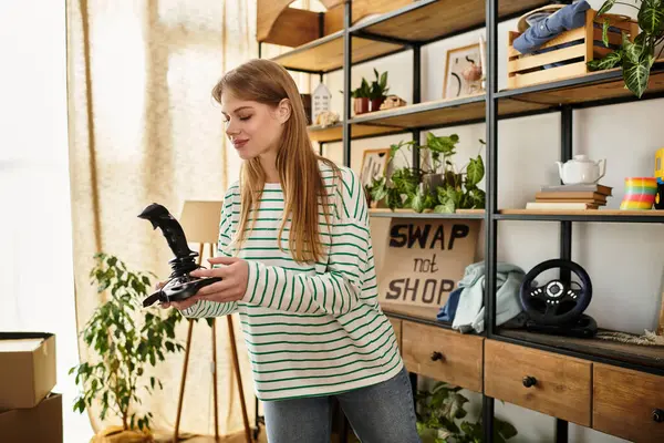 Una giovane donna ordina i vestiti nella sua elegante casa, promuovendo la sostenibilità con un sorriso. — Foto stock