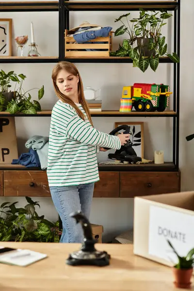 Jovem mulher dedicando tempo para classificar e doar coisas de jogos de vídeo em sua casa. — Fotografia de Stock