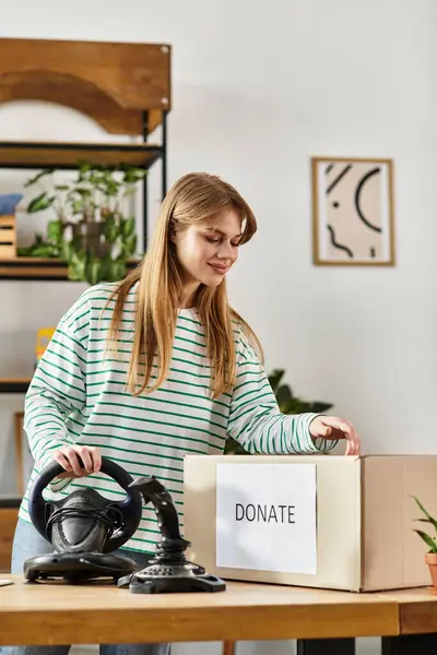 Uma jovem bonita organiza ativamente seus bens para doação, promovendo a sustentabilidade em casa. — Fotografia de Stock