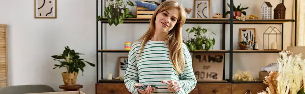 Молодая женщина счастливо организовывает свою одежду для пожертвования, продвигая устойчивый образ жизни, баннер — стоковое фото