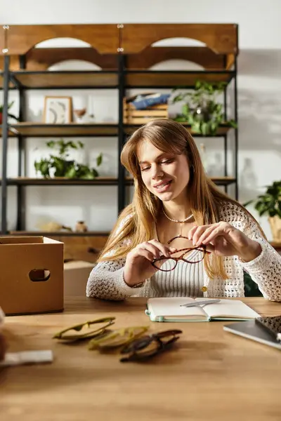 Una mujer joven cuidadosamente clasifica su ropa y accesorios, centrándose en la sostenibilidad y dando. - foto de stock