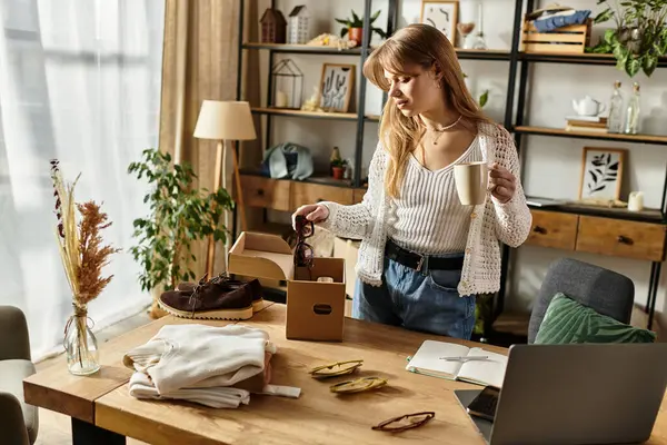 Mujer joven dedicada clasifica a través de ropa para donar, la promoción de un estilo de vida sostenible. - foto de stock