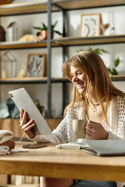 Young woman engaged in online donation while enjoying her warm drink. — Stock Photo