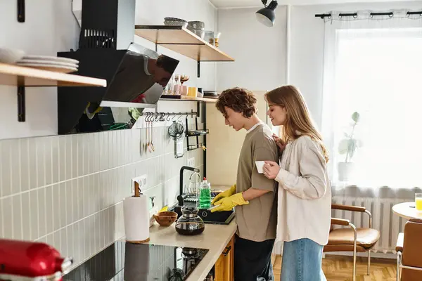 Dos personas disfrutan de un momento acogedor en casa, deleitándose en hacer café juntos. - foto de stock