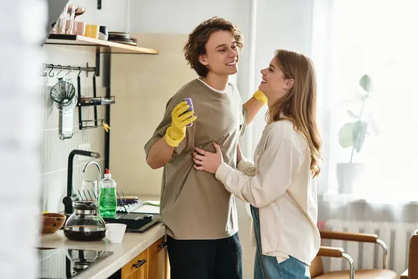Loving couple enjoys a cozy moment together while tidying up their stylish kitchen space. — Stock Photo