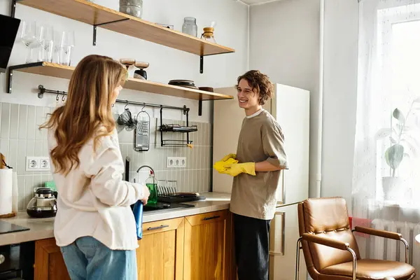 Um casal amoroso arruma sua cozinha moderna, compartilhando sorrisos e risos em sua casa. — Fotografia de Stock