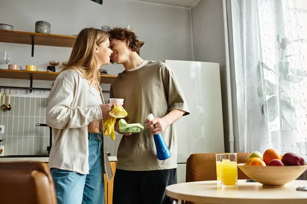 Couple enjoys a soft moment in their modern kitchen as they clean and connect at home. — Stock Photo