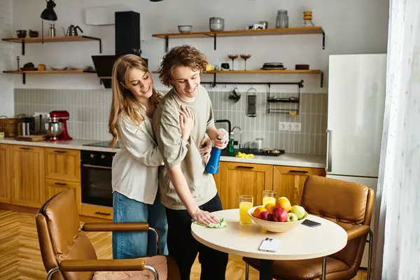 Young couple shares a joyful moment while tidying up their comfortable kitchen space at home. — Stock Photo
