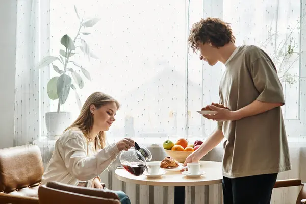 Loving couple shares a beautiful morning at home, pouring coffee and savoring delicious treats. — Stock Photo