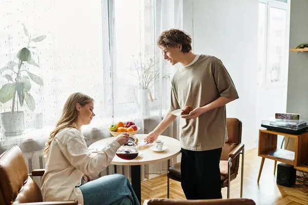 A young couple shares a delightful breakfast at home, savoring warm moments and tasty treats. — Stock Photo