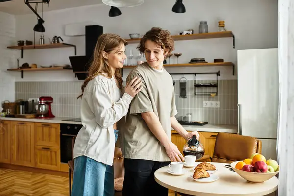 Una pareja cariñosa comparte un hermoso momento de desayuno en su cómoda cocina, llena de sonrisas. - foto de stock