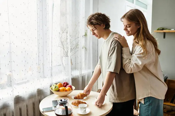 Una giovane coppia sta vicino al loro tavolo della cucina, condividendo la colazione e sorrisi dolci. — Foto stock