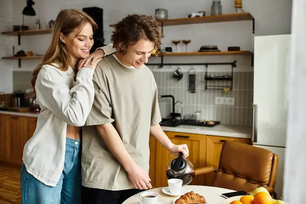 A couple enjoys a cozy moment in their stylish kitchen, pouring coffee and savoring pastries. — Stock Photo