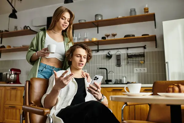 A loving couple shares a delightful morning as they connect over coffee and a smartphone. — Stock Photo