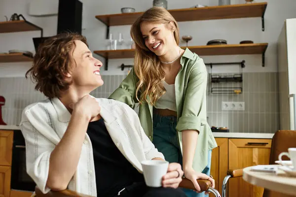 A loving couple shares a joyful moment, smiling and laughing in their modern kitchen. — Stock Photo