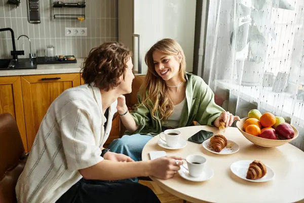 A young couple shares laughter and sweet moments while enjoying breakfast at home. — Stock Photo