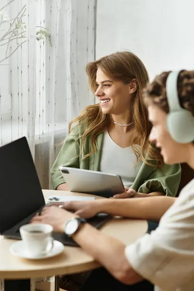 A loving couple shares a comfortable and modern space, working on laptops and enjoying drinks. — Stock Photo