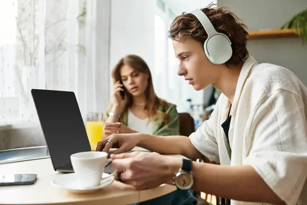 Pareja disfruta de tiempo de calidad en casa, conectado mientras trabaja en sus propias tareas. - foto de stock