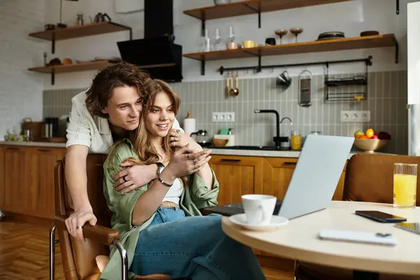 A young couple shares a joyful moment, absorbed in their conversation and laughter at home. — Stock Photo