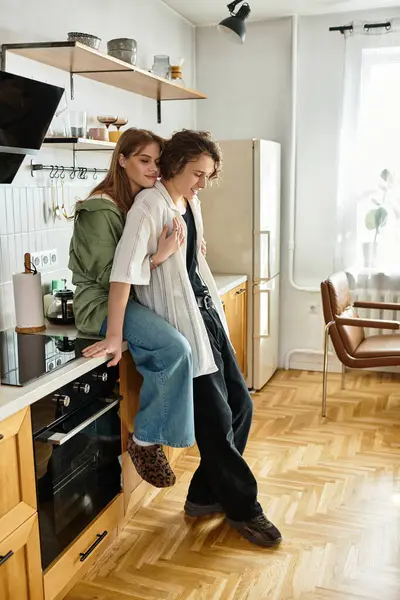 In a bright and modern kitchen, a loving couple shares a warm embrace, radiating joy and comfort. — Stock Photo