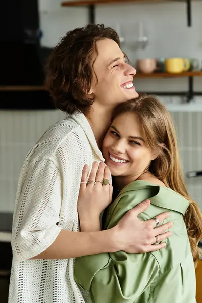 Loving couple embraces each other warmly at home, sharing joyful moments in a modern setting. — Stock Photo