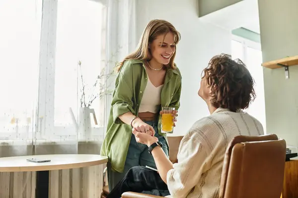 Loving couple enjoys a warm afternoon together, smiling and holding hands in their modern home. — Stock Photo