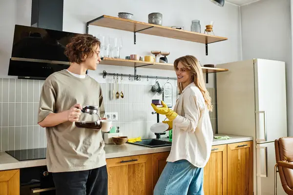 Pareja joven preparando alegremente el desayuno juntos, disfrutando de momentos dulces en su acogedora cocina - foto de stock