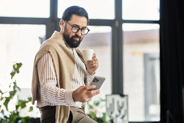 Schöner älterer Herr schlürft Kaffee und interagiert in gemütlicher Atmosphäre mit seinem Smartphone. — Stockfoto