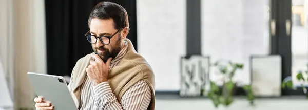 Senior man uses a tablet in a cozy, inviting atmosphere. — Stock Photo