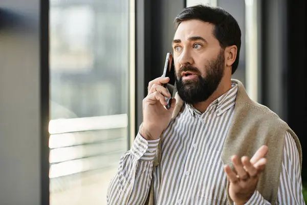 Casually dressed senior man deeply discusses something on his phone, showing heartfelt expressions. — Stock Photo