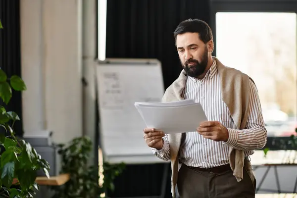 A dapper elderly man reads important papers in a bright, calm office. — Stock Photo