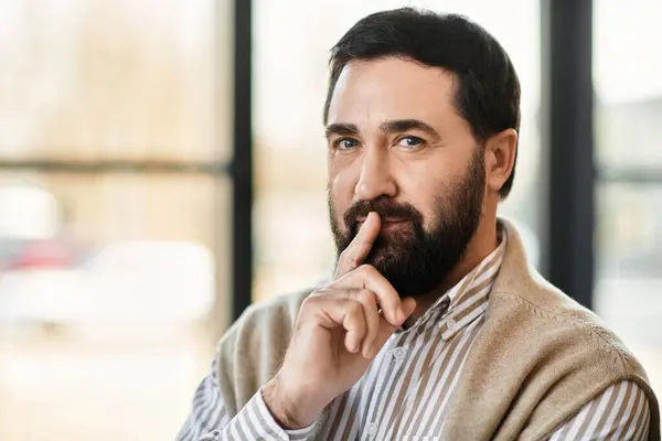 Handsome senior man in casual attire displays a contemplative look while seated peacefully. — Stock Photo