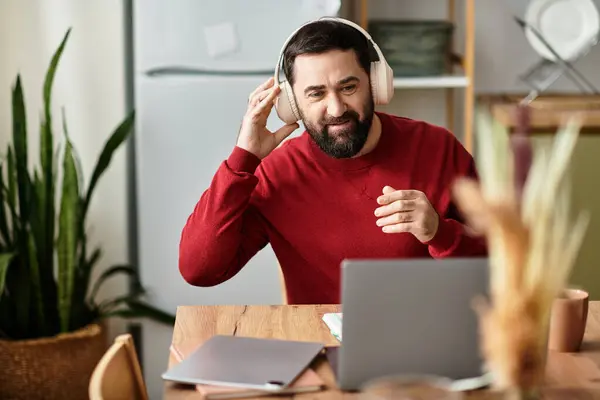 Handsome elderly man wearing headphones smiles while engaging with music in a warm setting. — Stock Photo