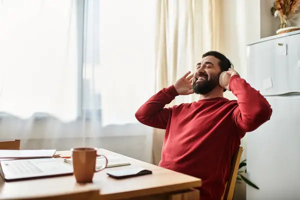 An elderly man sips coffee in a sunny, cozy room, enjoying a moment of peace. — Stock Photo
