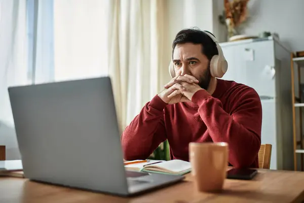 Un homme âgé distingué en tenue décontractée réfléchit attentivement tout en assistant à une réunion en ligne. — Stock Photo