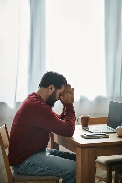 Привабливий старший чоловік сидить за дерев'яним столом, занурений у думки біля вікна — Stock Photo
