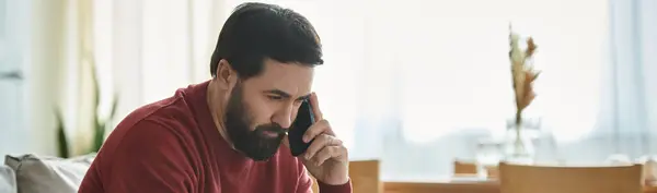A stylish senior man in casual wear talks on the phone, showing a thoughtful look. — Stock Photo