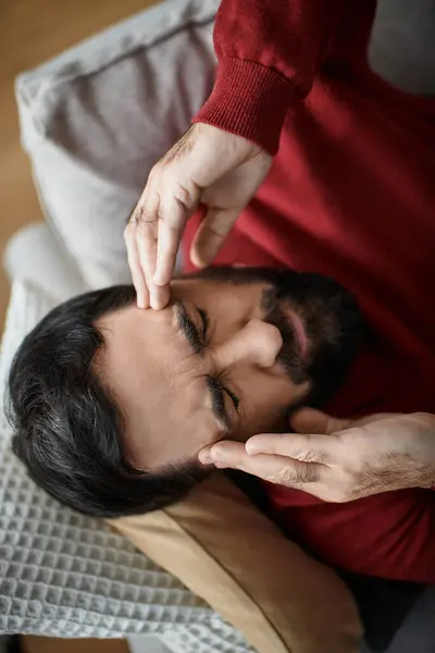 A handsome senior man reclines on a soft sofa, cherishing a peaceful moment in casual attire. — Stock Photo