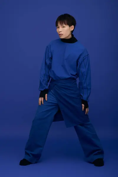 A confident young man poses in stylish blue clothing, exuding modern charm. — Stock Photo