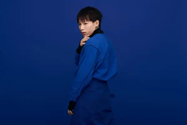 A young handsome asian man poses confidently in a striking blue outfit, showcasing modern style. — Stock Photo