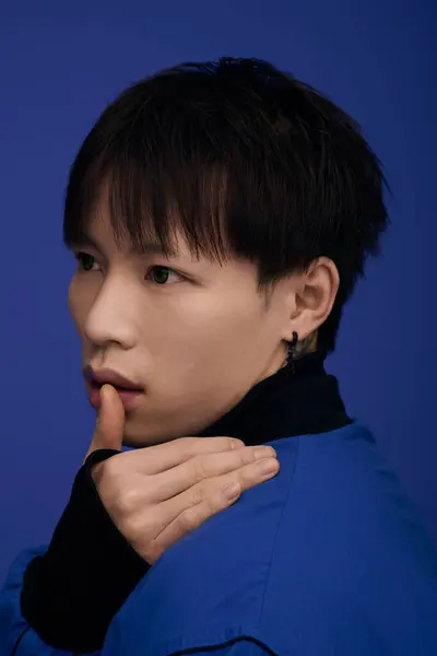 Young attractive asian man poses with a pensive expression, highlighting his stylish look and charm — Stock Photo