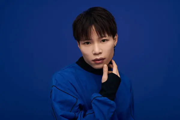 Young man in a stylish blue outfit gazes confidently, creating a striking contrast. — Stock Photo