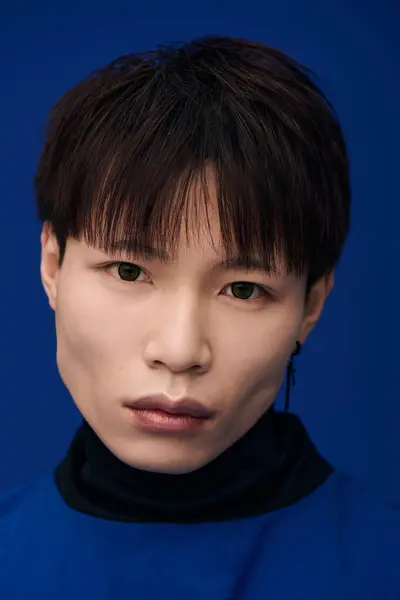 A striking young Asian man gazes intently, showcasing his attractive features and expressive eyes. — Stock Photo