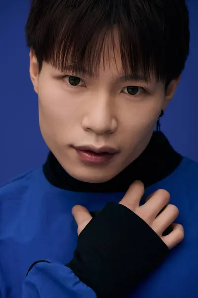 Attractive young man in a blue outfit poses confidently with a mesmerizing expression. — Stock Photo