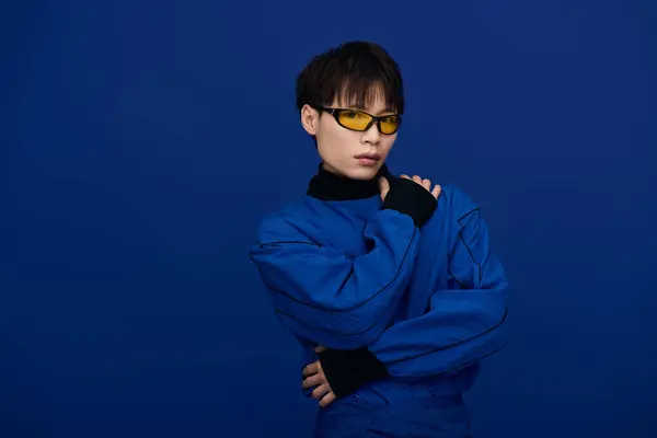 Stylish young Asian man in a bold blue outfit and sunglasses showcases modern fashion. — Stock Photo