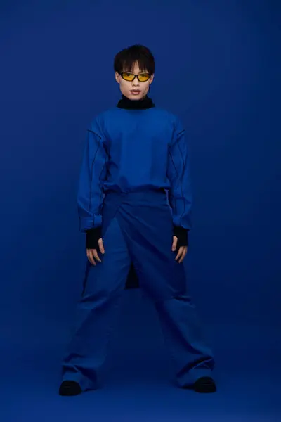 A young attractive asian man stands confidently in a bold blue outfit, exuding charisma. — Stock Photo