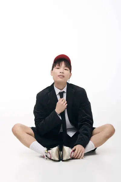 A young Asian man poses confidently in a stylish outfit, highlighting his fashion sense. — Stock Photo