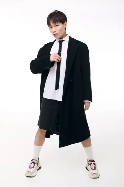 Young Asian man displays modern fashion with charm in a minimalist setting. — Stock Photo